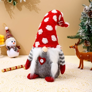Close-up of a handmade Christmas gnome with a red heart and festive decorations