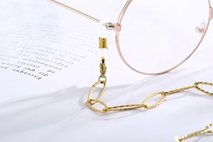 Detailed close-up of golden stainless steel chain link with white anti-slip silicone loops