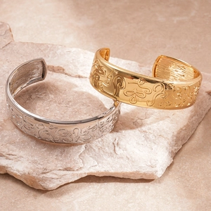Embossed floral vintage cuff bangle in gold and silver finishes on natural stone base