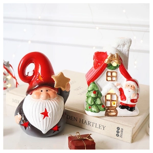Detail of light-up ceramic Santa Claus gnome and snowy house figurines on book