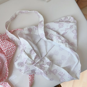 Détail de sacs en coton doux avec des motifs de nœuds papillon rouges et violets