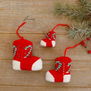 Knitted Christmas stockings with candy cane patterns on vintage wooden background
