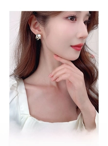 Gros plan de boucles d'oreilles carrées en perles baroques sur un mannequin