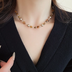 Detailansicht der Perlenkette mit Tigerauge-Steinen und Champagner-Perlen am Hals