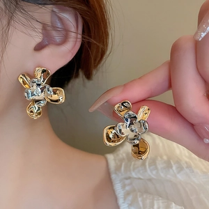 Detailed view of large metallic flower earrings in two-tone gold and silver finish