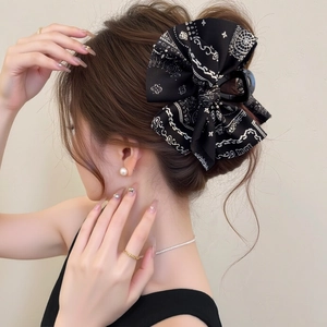 Dettaglio di pinza per capelli con fiocco bandana nero e trama del tessuto alla moda
