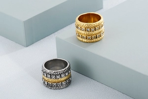 Detail of wide stainless steel rings with hammered texture and double rows of crystals