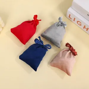 Set of four velvet drawstring jewelry pouches in red, blue, grey, and pink colors
