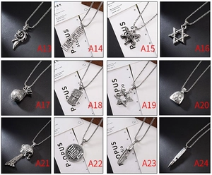 Detailed close-up of 12 assorted vintage hip-hop pendants including skull and military tags
