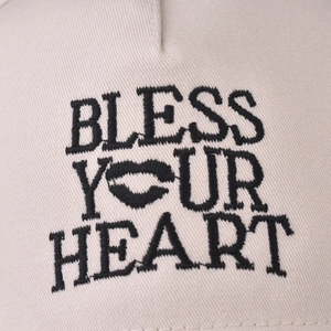 Beige cotton baseball cap featuring black 'Bless Your Heart' embroidery with lip pattern