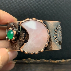 Detailaufnahme der antiken Kupfermanschette mit Rosenquarzmond und Sonnenreliefmustern