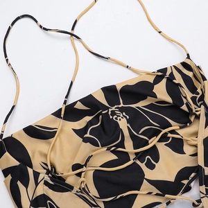 Detail of floral backless dress showing yellow-black print and thin lace-up straps