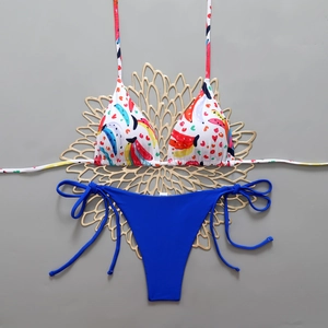 Flat lay detail of floral banana print bikini top and navy blue side-tie bottoms