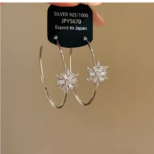 Détail des boucles d'oreilles créoles flocon de neige en argent 925 avec zircons