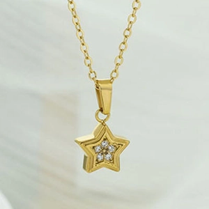 Macro detail of gold star pendant necklace with six white cubic zirconia stones set in center