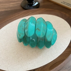 Macro shot of turquoise marble-patterned acrylic stretch bracelet segments