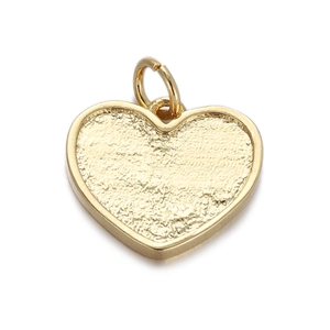 Macro view of a golden heart-shaped metal pendant with textured finish and ring