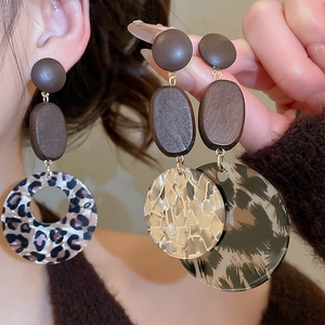 Detail von Vintage-Ohrringen mit braunen Kreisen und Anhänger mit Leopardenmuster