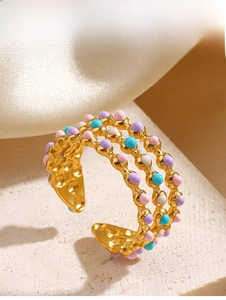 Detailed macro view of the three-layer gold wavy ring with colorful enamel beads
