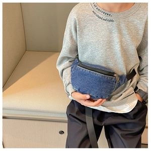 Kid's blue denim waist bag worn by model showing casual crossbody fit on chest