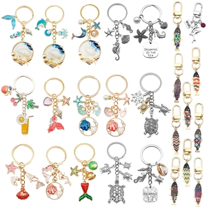 Detail of ocean-themed keychains featuring starfish and turtle with enamel and rhinestones