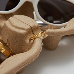 Minimalist 18K gold stainless steel open ring displayed on textured industrial packaging