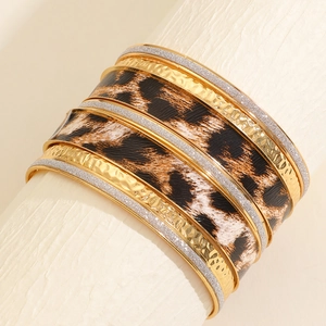 Close-up of bohemian layered bracelet set with leopard print and golden textured details