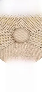 Close-up of DH&NY letter embroidery and breathable mesh on a beige baseball cap