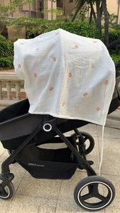 Detail of breathable white gauze stroller cover with apple pattern for sun protection