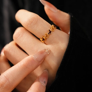 Detail of 18k gold butterfly ring with deep enamel inlay on a hand model
