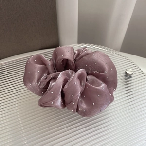 Detail of silk satin scrunchie in dusty rose with sparkling rhinestone embellishments