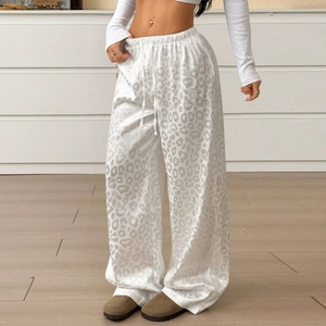 Close-up of leopard print lounge pants with elastic drawstring waist and fluid drape