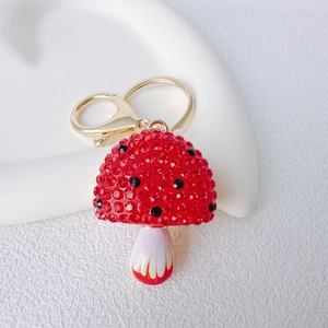 Macro shot of red and black rhinestones on a mushroom keychain with golden metal ring