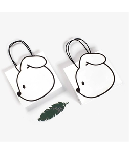 Close-up of thick paper gift bags with minimalist rabbit print and love feather tag