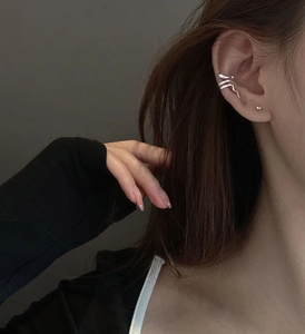 Close-up of a silver snake-shaped ear cuff worn on the upper ear for non-pierced ears