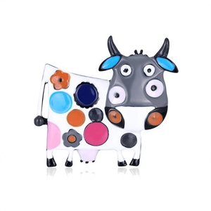 Detailed view of a cute cartoon cow brooch with colorful floral patterns and enamel finish