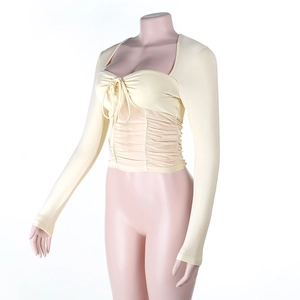 Detail of drawstring neckline and pleated bodice on a slim-fit cream knit long sleeve top