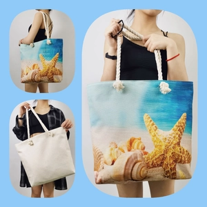 Canvas beach tote bag with starfish shell print and white rope handle on blue background