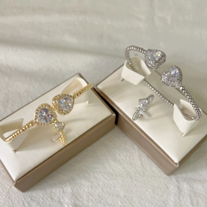 Detail of beaded gold and silver heart bracelets with clear zircons in a gift box