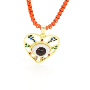 Dettaglio del ciondolo a cuore malocchio con zirconi colorati e cordino intrecciato arancione