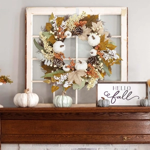 Autumn wreath with white pumpkins, pine cones and berries on a rustic wood background