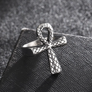 Macro shot of silver Ankh cross ring with snake scale texture on a black leather stand