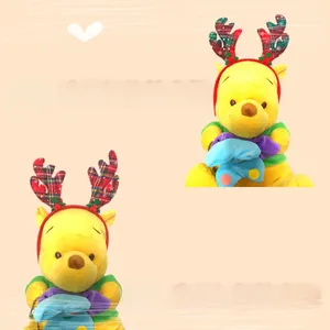 Détail de peluche Winnie l'Ourson de Noël avec décoration de bois de renne à carreaux