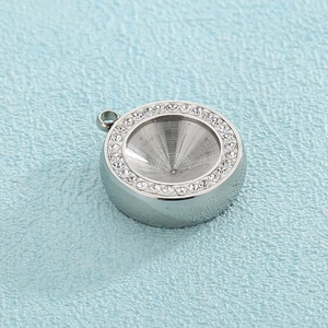 Macro detail of round stainless steel pendant with crystal rhinestones and conical groove