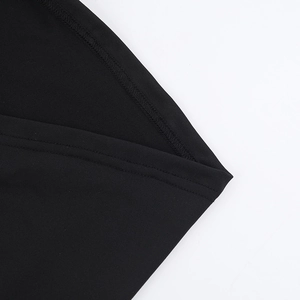 Détail en gros plan de l'ourlet à double couture sur une robe noire ajustée et élégante