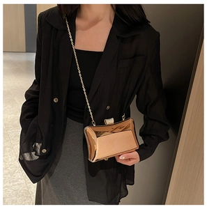 Detailansicht einer roségoldenen Clutch mit luxuriösem Kristallverschluss und Goldkette