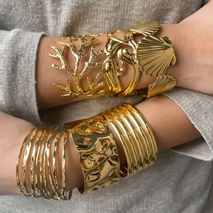 Dettaglio di lussuosi bracciali in acciaio inossidabile dorato con varie trame