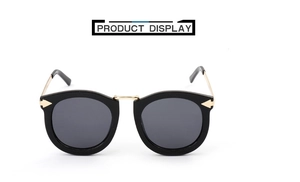 Detail of vintage cat-eye sunglasses with thick black frames and gold bridge and temples