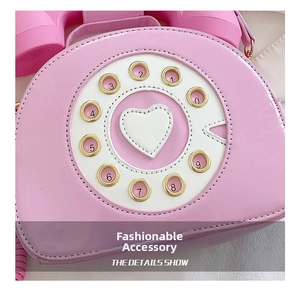 Detail of creative pink patent leather crossbody bag in vintage telephone shape design
