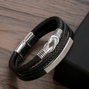 Handmade woven leather multi-layer bracelet with silver magnetic clasp and knot on wood